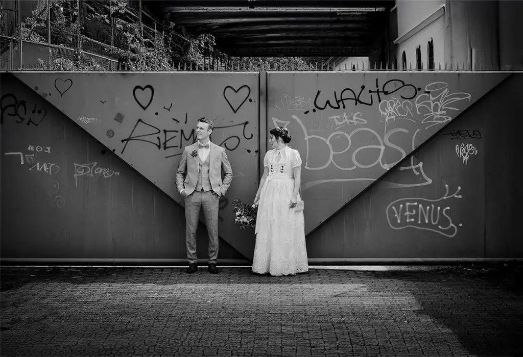 Hochzeitsfoto in Karlsruhe vor einer mit Graffiti verzierten Wand, Brautpaar in Tracht, Schwarz-Weiß-Aufnahme